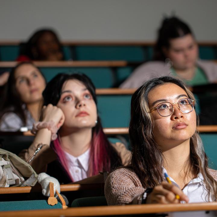 Students sat in a lecture theatre listening to a lecture
